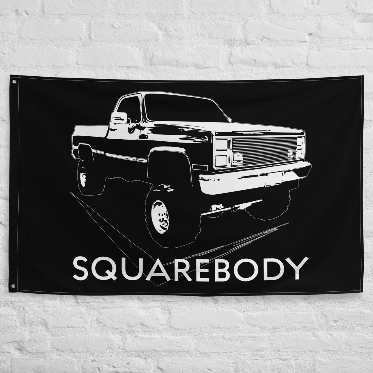 Square Body Lifted 80s Flag Truck hung on brick wall