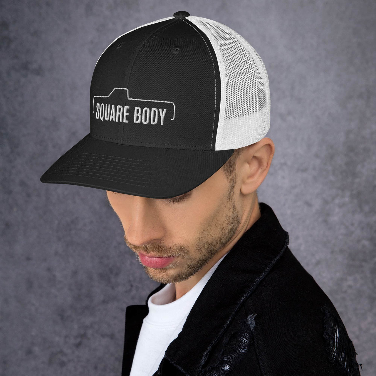 man wearing a Square body c10 k10 trucker hat from aggressive thread in black and white