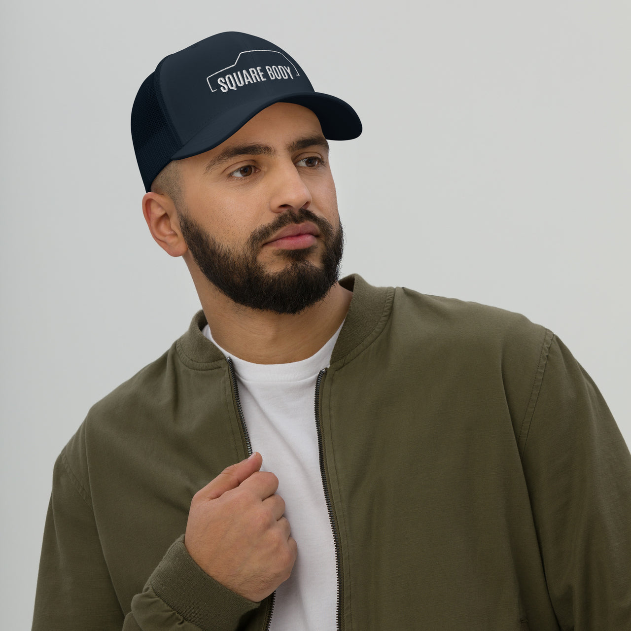 man wearing a side view of a Square body K5 blazer trucker hat from aggressive thread in navy