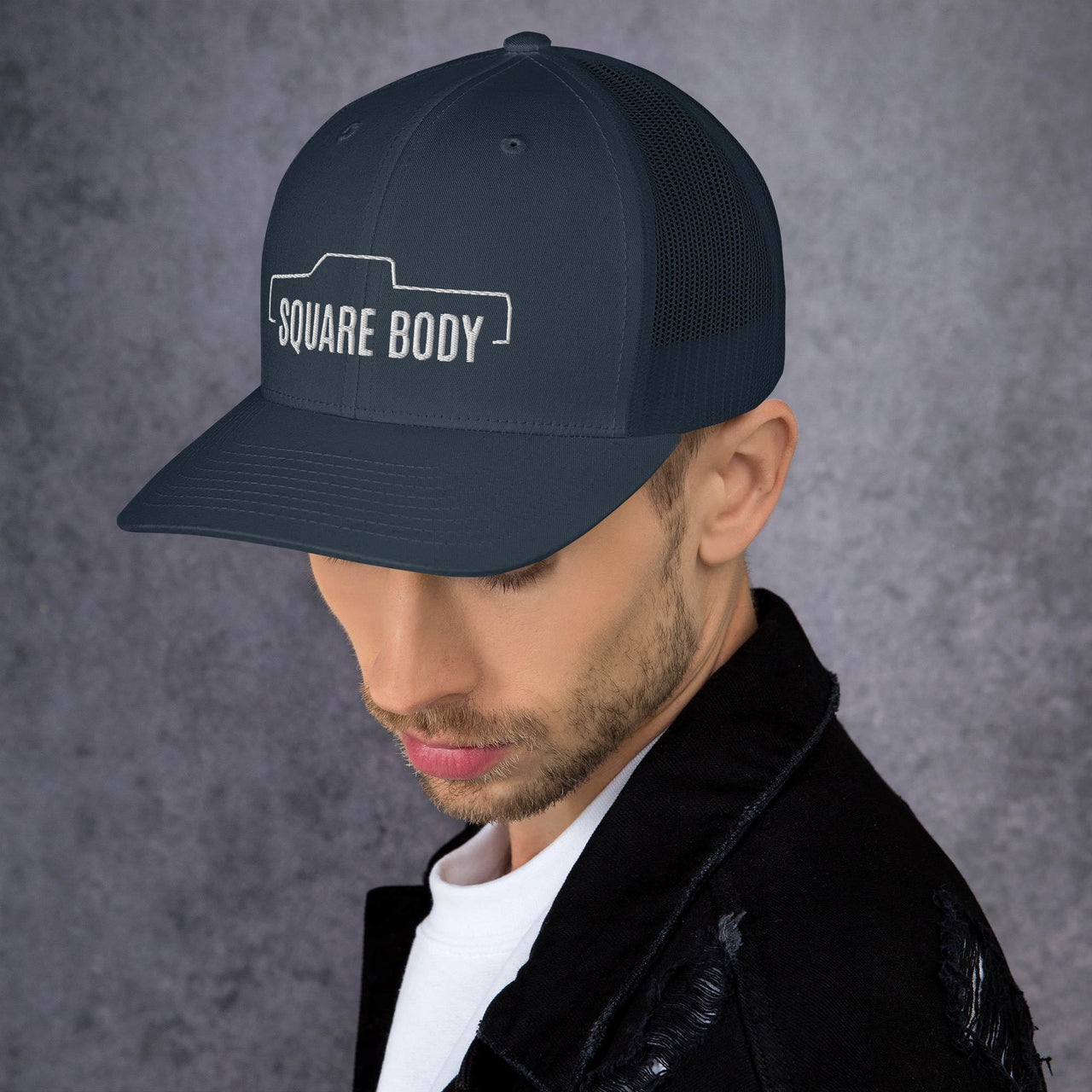 Man wearing a Crew Cab Square Body Trucker Hat From Aggressive Thread in Navy