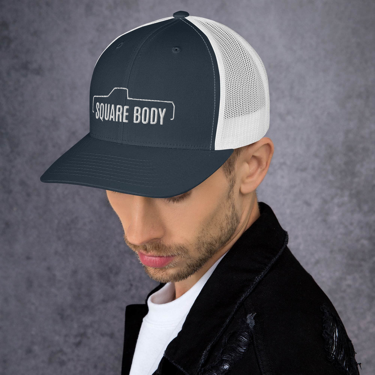 man wearing a Square body c10 k10 trucker hat from aggressive thread in navy and white